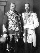 Dos hombres con barba de idéntica altura visten uniformes de vestir militares estampadas con medallas y se colocan de lado a lado