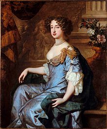 retrato de una mujer con el pelo marrón en un vestido azul y gris