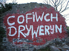 un muro en ruinas, salpicado con pintura roja, en la que en la pintura blanca que está escrito las palabras 'cofiwch Dryweryn'
