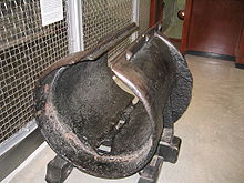 Una sección corta de tubería de hierro, alrededor de un diámetro de pie, con una ranura en la superficie superior