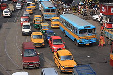 Uma estrada congestionada mostrando ônibus, táxis, autorikshaws e outros modos de transporte rodoviário